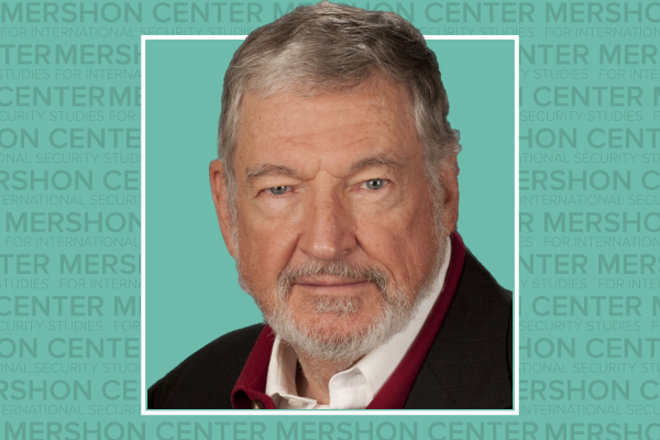 Photo of John Mueller with the repeating gray text Mershon Center on a teal background